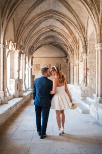 Couple de mariés marchant sous les arcades lors d’un mariage en Provence